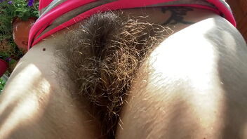 Close up of an outdoor shoot of an amateur’s hairy thicket with a fetish focus on a humungous clit.